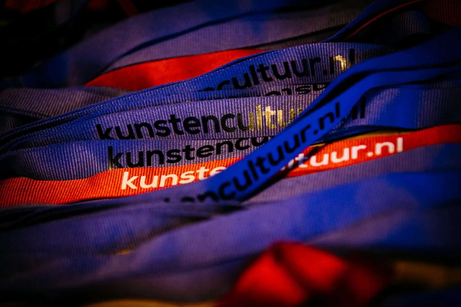 Linten met opdruk "kunsten cultuur.nl" in verschillende kleuren.