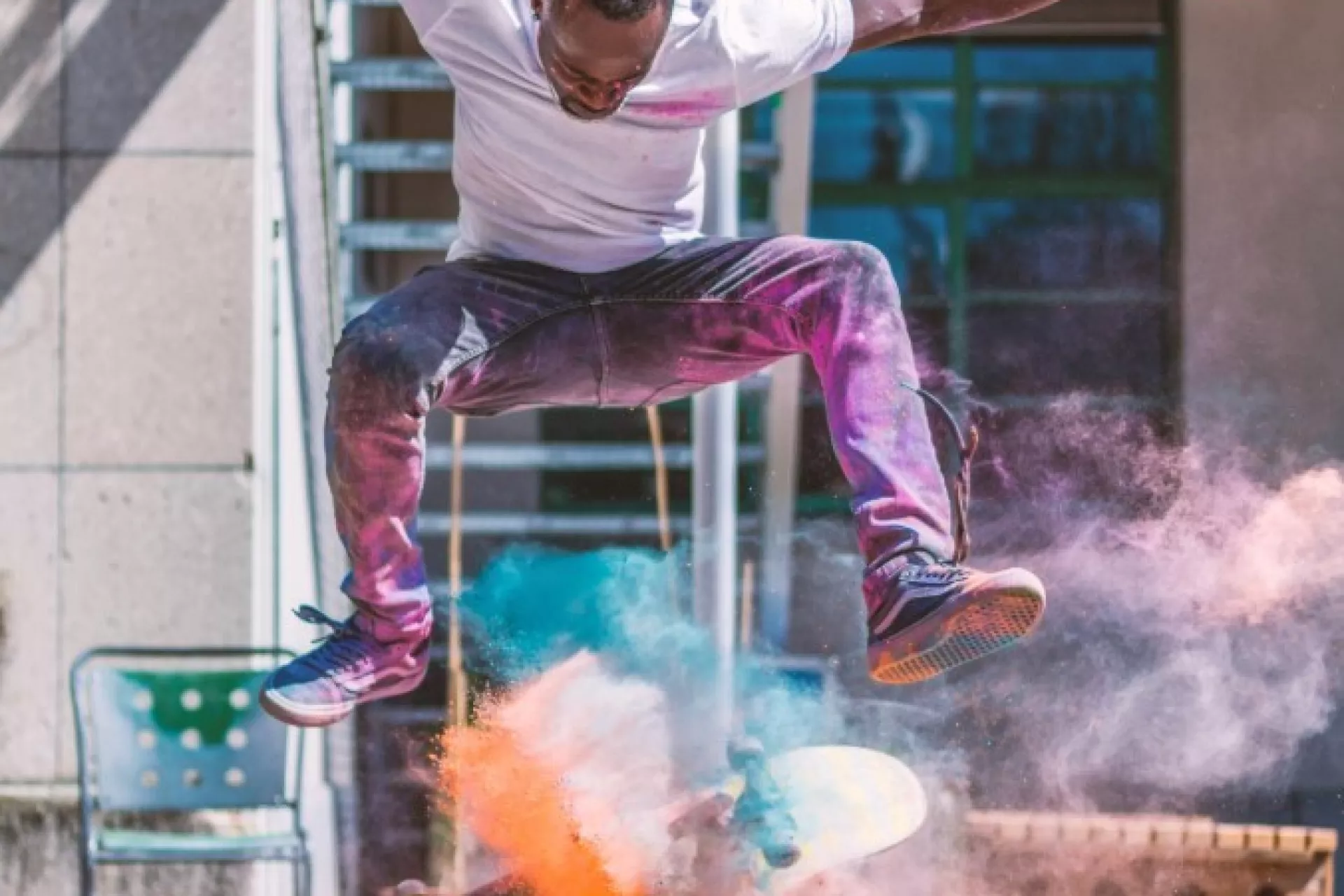 Skateboarder voert een sprong uit met kleurrijke rook om zich heen.